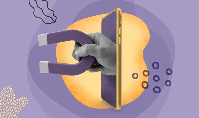 Ilustração de uma mão, que segura um íma, saindo da tela de um celular.
