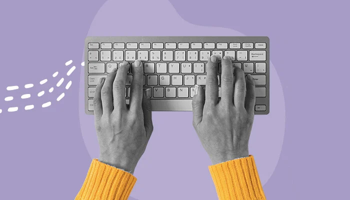 Duas mãos digitando em um teclado.