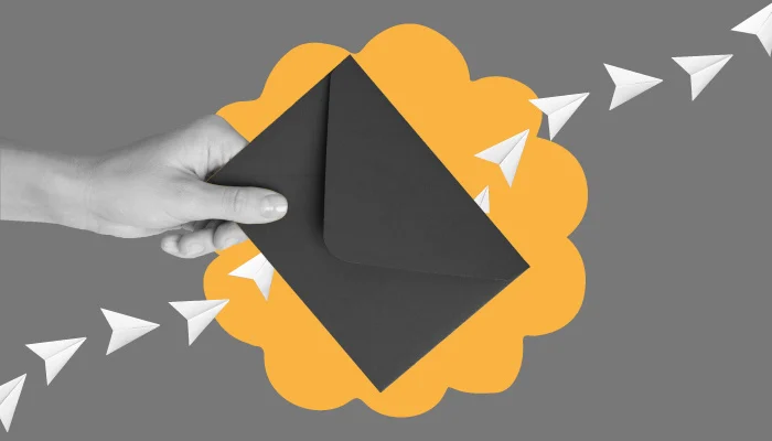 Uma mão segura um envelope preto.