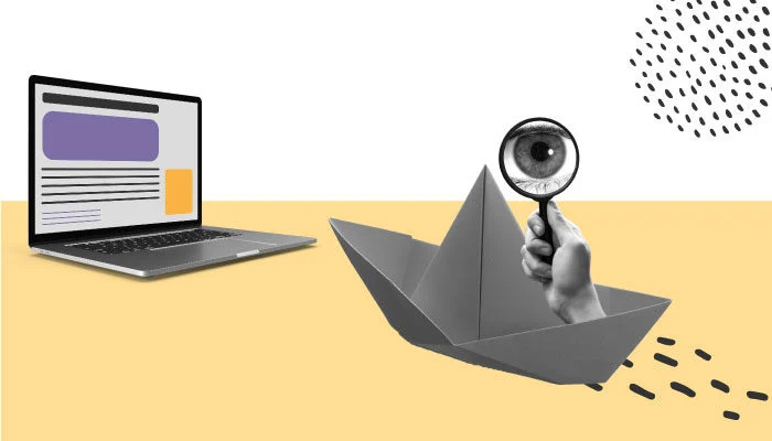 Um computador e um barco de papel com uma lupa