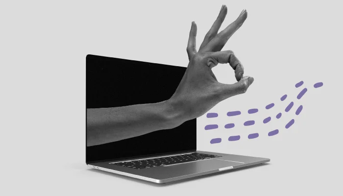 Uma mão sai de um notebook e faz um sinal de "peteleco".